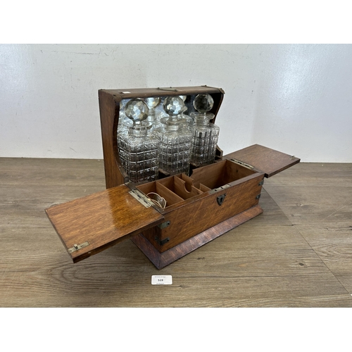 519 - A 19th century oak tantalus with three cut glass decanters - approx. 30cm high x 33cm wide x 27cm de... 