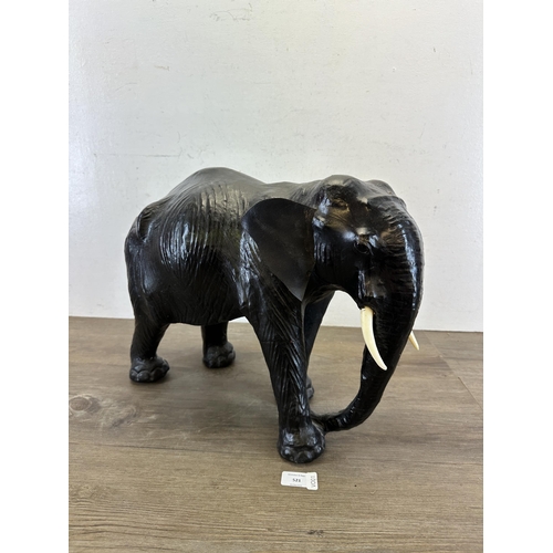 521 - A mid 20th century Liberty style black leather fireside elephant - approx. 39cm high x 49cm long