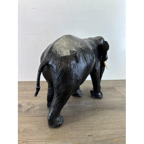 521 - A mid 20th century Liberty style black leather fireside elephant - approx. 39cm high x 49cm long