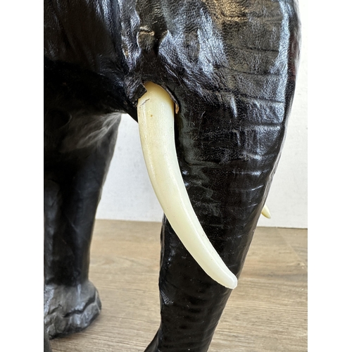 521 - A mid 20th century Liberty style black leather fireside elephant - approx. 39cm high x 49cm long