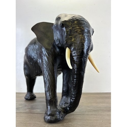 521 - A mid 20th century Liberty style black leather fireside elephant - approx. 39cm high x 49cm long