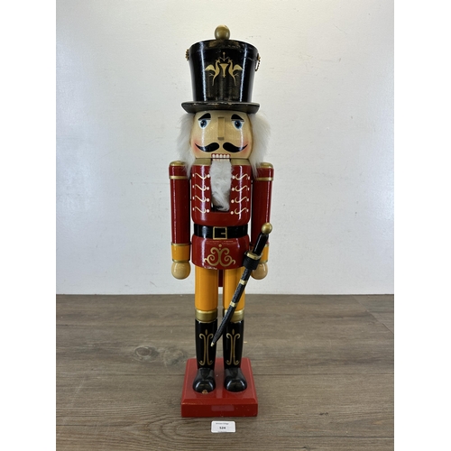 524 - A wooden hand-painted floor standing soldier nutcracker - approx. 59cm high