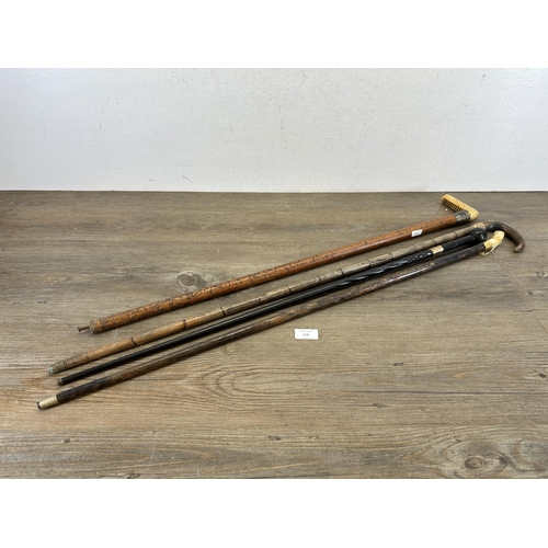 534 - Four antique walking canes, carved ebony with 18ct gold plated ferule, bamboo with horn handle and y... 