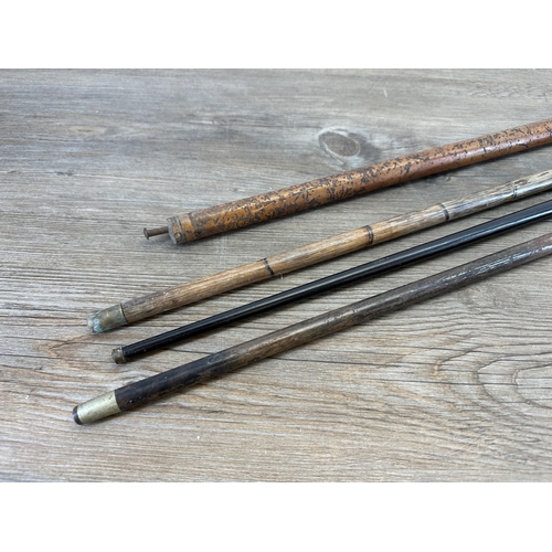 534 - Four antique walking canes, carved ebony with 18ct gold plated ferule, bamboo with horn handle and y... 