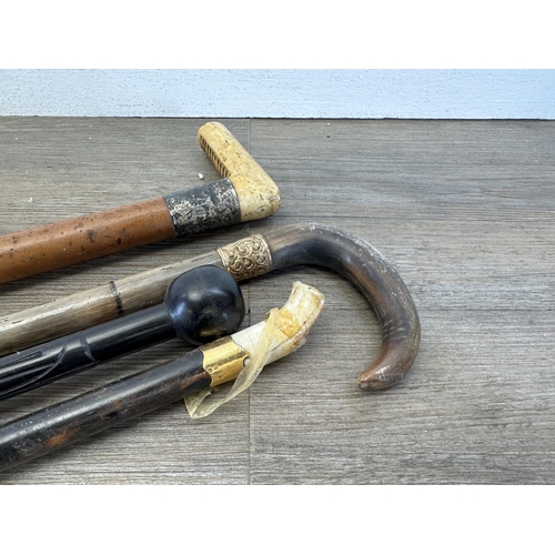 534 - Four antique walking canes, carved ebony with 18ct gold plated ferule, bamboo with horn handle and y... 