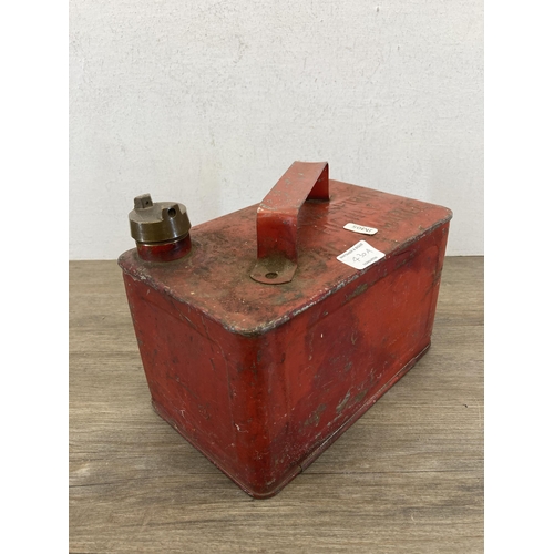 430A - A mid 20th century red metal petrol can with brass top