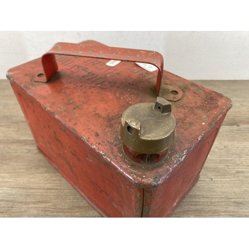 430A - A mid 20th century red metal petrol can with brass top