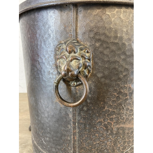 434 - A vintage cast metal coal bucket with lion head handles, lion paw feet and brass spherical top - app... 