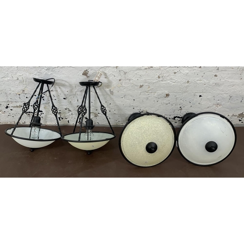 163 - Four modern wrought metal and opaque glass pendant lights