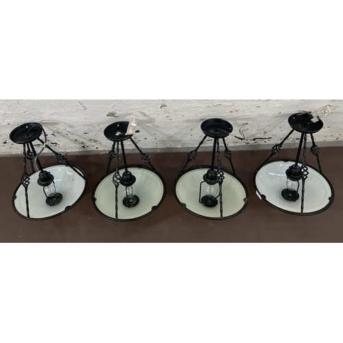 163 - Four modern wrought metal and opaque glass pendant lights