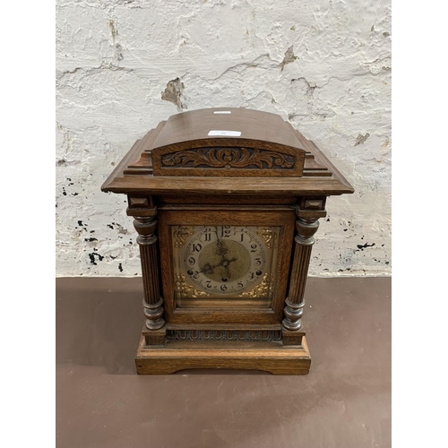 46 - An early 20th century German Kienzle carved oak cased chiming mantel clock with pendulum and key - a... 