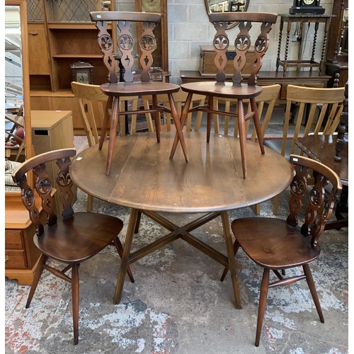 61 - A mid 20th century Ercol Old Colonial No. 377 elm and beech circular drop leaf dining table and four... 