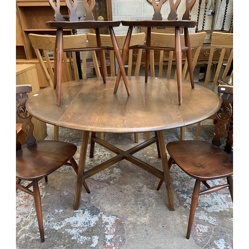 61 - A mid 20th century Ercol Old Colonial No. 377 elm and beech circular drop leaf dining table and four... 