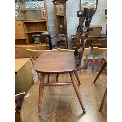 61 - A mid 20th century Ercol Old Colonial No. 377 elm and beech circular drop leaf dining table and four... 