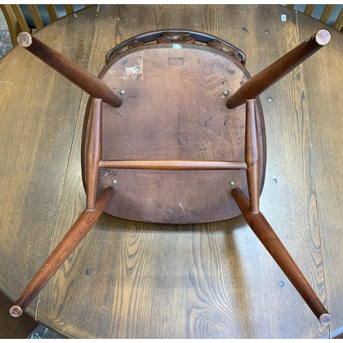 61 - A mid 20th century Ercol Old Colonial No. 377 elm and beech circular drop leaf dining table and four... 