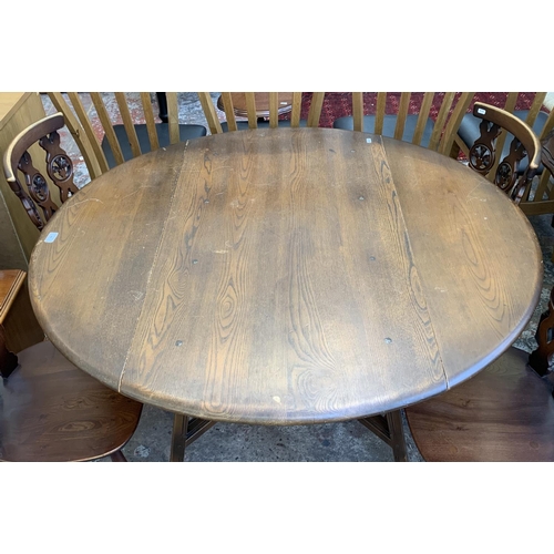 61 - A mid 20th century Ercol Old Colonial No. 377 elm and beech circular drop leaf dining table and four... 