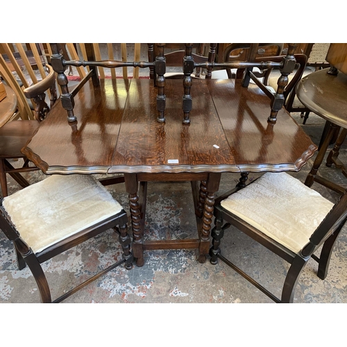 62 - An early 20th century oak pie crust edge drop leaf gate leg dining table on barley twist supports an... 