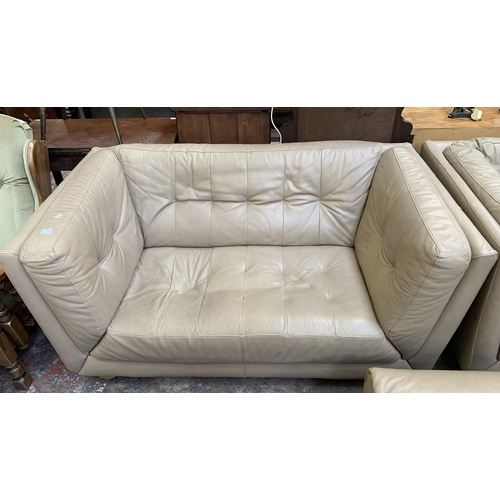 66 - A modern beige leather three piece lounge suite comprising two seater sofa, armchair and footstool