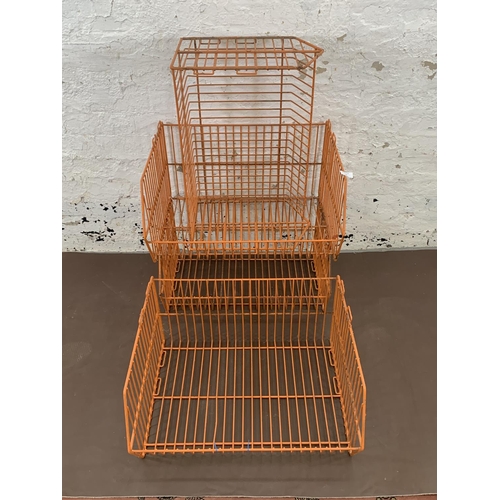 72 - Four mid 20th century orange wired metal shop display baskets - approx. 33cm high x 59cm wide x 49cm... 