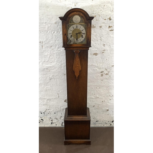 94 - An Art Deco Enfield Clock Co. London Ltd oak cased chiming granddaughter clock with two keys and pen... 