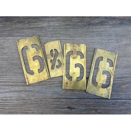 513 - Two galvanized tins containing a collection of brass letter and number stencils