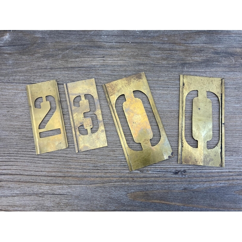 513 - Two galvanized tins containing a collection of brass letter and number stencils