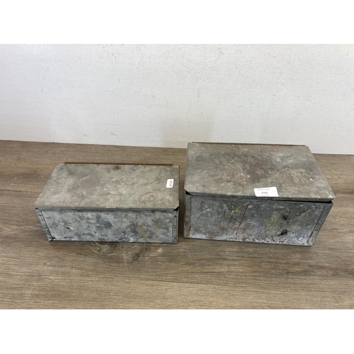 513 - Two galvanized tins containing a collection of brass letter and number stencils