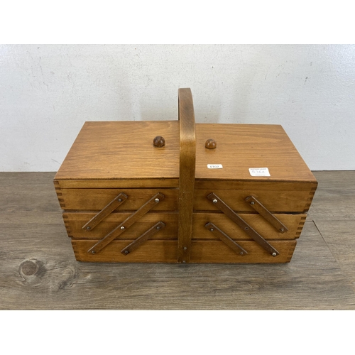 516A - A mid 20th century oak and beech cantilever sewing box containing various sewing accessories to incl... 