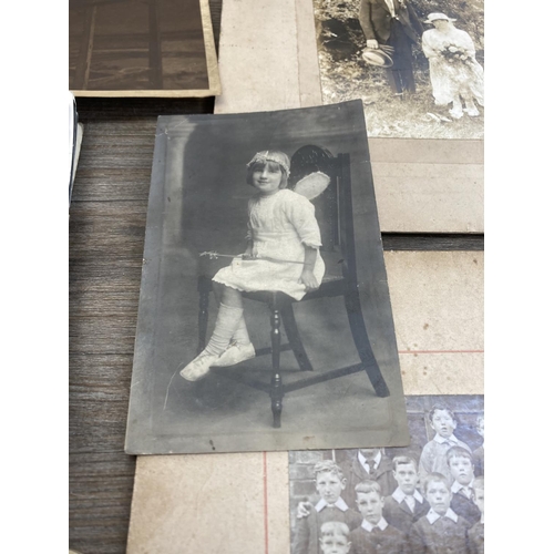 498 - A collection of antique and later black and white photographs and postcards