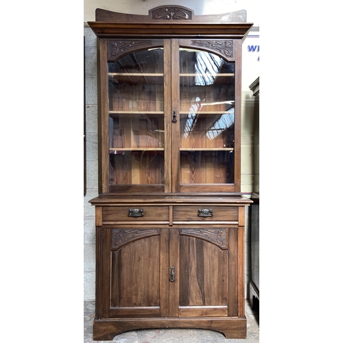 1 - An Art Nouveau carved walnut bookcase - approx. 222cm high x 106cm wide x 48cm deep