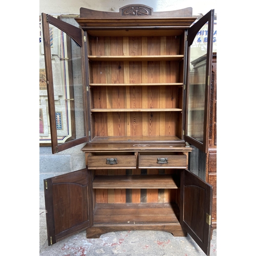 1 - An Art Nouveau carved walnut bookcase - approx. 222cm high x 106cm wide x 48cm deep