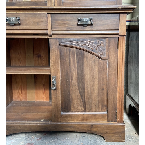 1 - An Art Nouveau carved walnut bookcase - approx. 222cm high x 106cm wide x 48cm deep