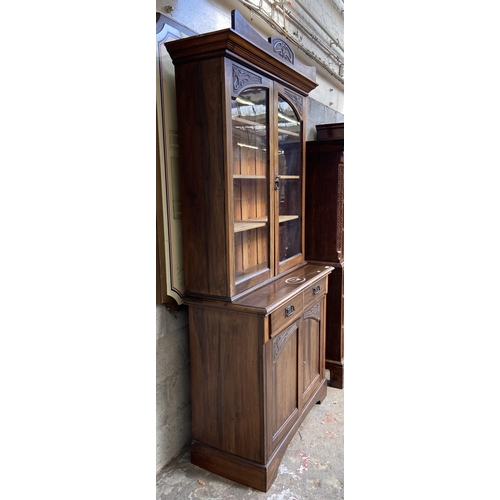 1 - An Art Nouveau carved walnut bookcase - approx. 222cm high x 106cm wide x 48cm deep