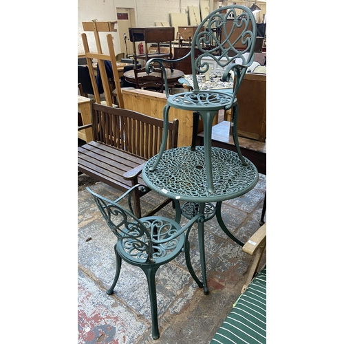 126 - A Victorian style green painted cast metal three piece patio set comprising circular table and two c... 