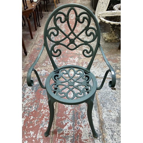 126 - A Victorian style green painted cast metal three piece patio set comprising circular table and two c... 