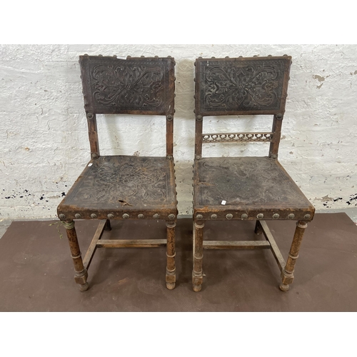 129 - A pair of Cromwellian style carved beech and brown leather dining chairs