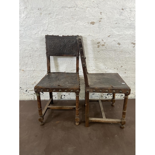 129 - A pair of Cromwellian style carved beech and brown leather dining chairs