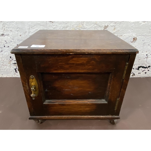 17 - An early 20th century oak single door cabinet on later added castors - approx. 32cm high x 35cm wide... 