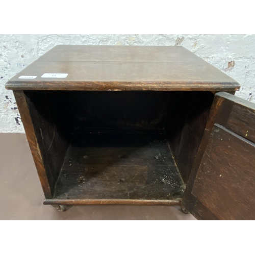 17 - An early 20th century oak single door cabinet on later added castors - approx. 32cm high x 35cm wide... 