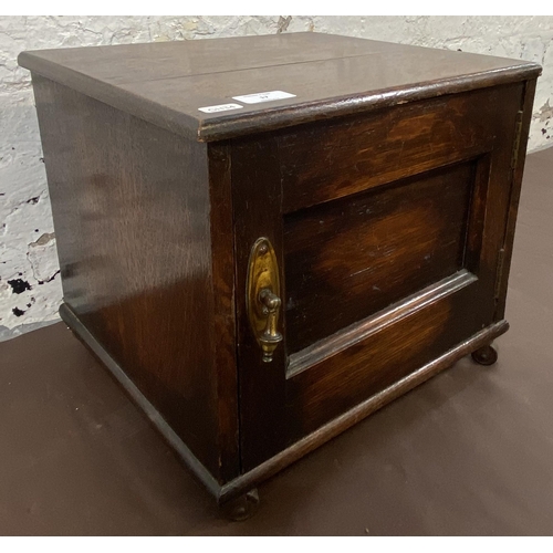 17 - An early 20th century oak single door cabinet on later added castors - approx. 32cm high x 35cm wide... 