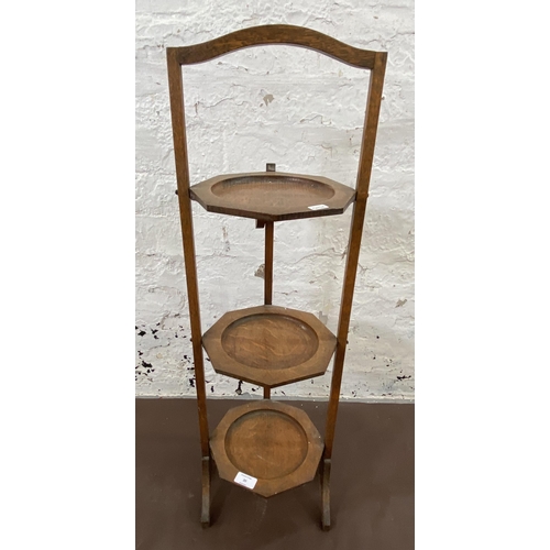 20 - An early 20th century oak three tier folding cake stand - approx. 82cm high