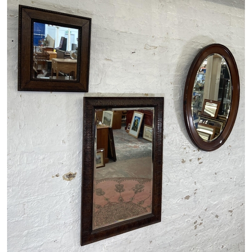 23 - Three early 20th century framed wall mirrors, two oak and one mahogany - largest approx. 90cm high x... 