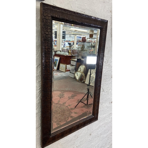 23 - Three early 20th century framed wall mirrors, two oak and one mahogany - largest approx. 90cm high x... 