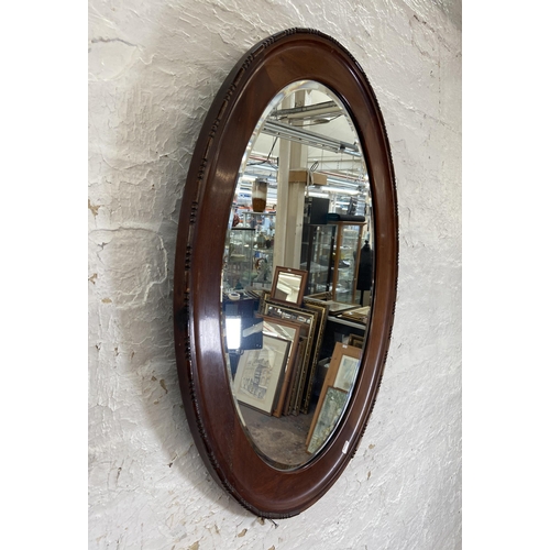 23 - Three early 20th century framed wall mirrors, two oak and one mahogany - largest approx. 90cm high x... 