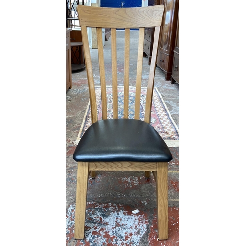 41 - Four modern oak and black faux leather dining chairs