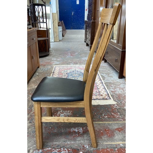 41 - Four modern oak and black faux leather dining chairs