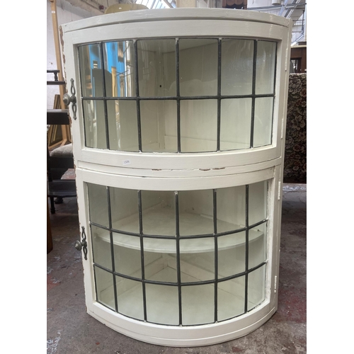 76 - A mid 20th century white painted and lead glazed wall mountable two door corner display cabinet