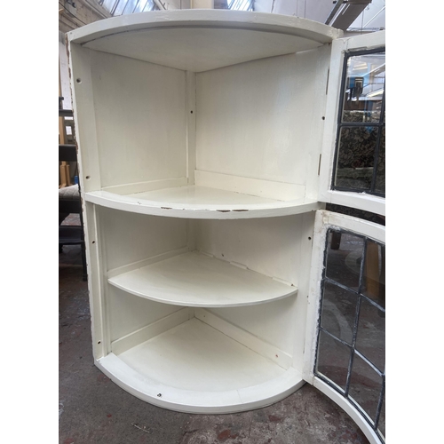 76 - A mid 20th century white painted and lead glazed wall mountable two door corner display cabinet