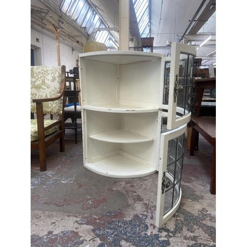 76 - A mid 20th century white painted and lead glazed wall mountable two door corner display cabinet