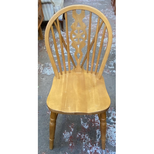 87 - Four beech wheelback dining chairs